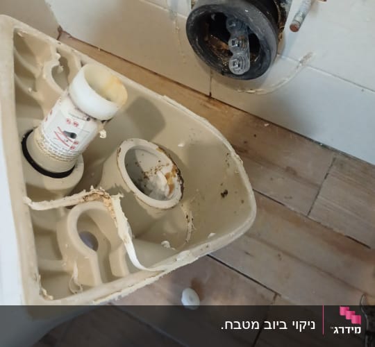 חלקי אסלה וכלי עבודה על רצפה
